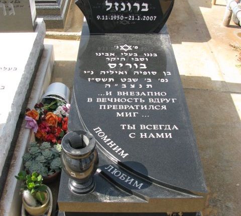 מצבה שחורה עם חריטת גלים וכד בצד