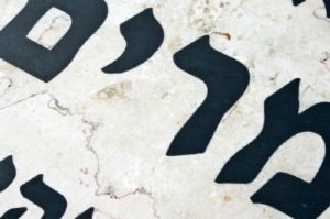כיתוב שחור חרוט על שיש המצבה המיוחדת