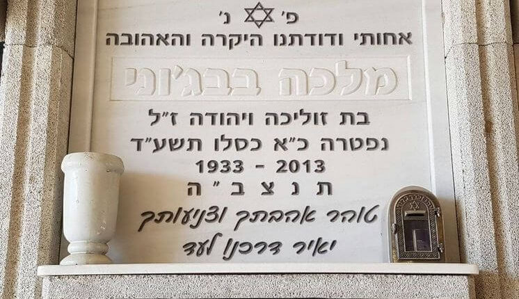 מצבה לבנה עם כיתוב שחור