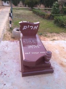 מצבה בצפון מגרניט אדומה וכיתוב לבן