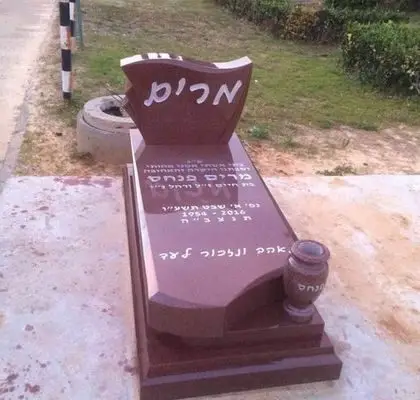 מצבה בצפון מגרניט אדומה וכיתוב לבן