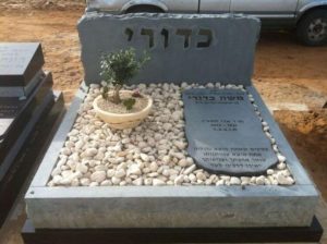 מצבות בצפון מאבן חברון כהה וחצץ בשילוב פרחים